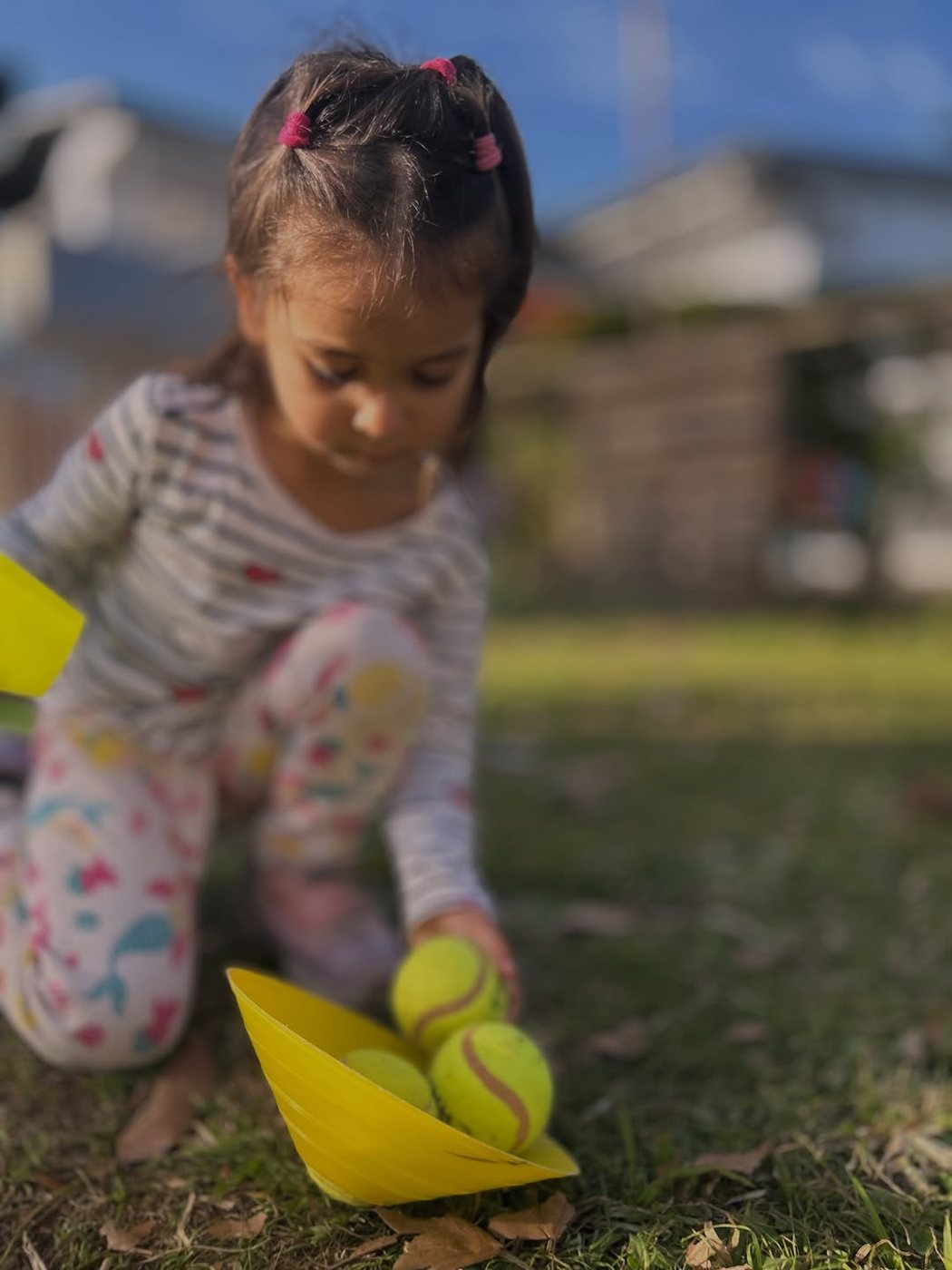 Criança brincando na grama do pátio da Escola Amor de Mãe